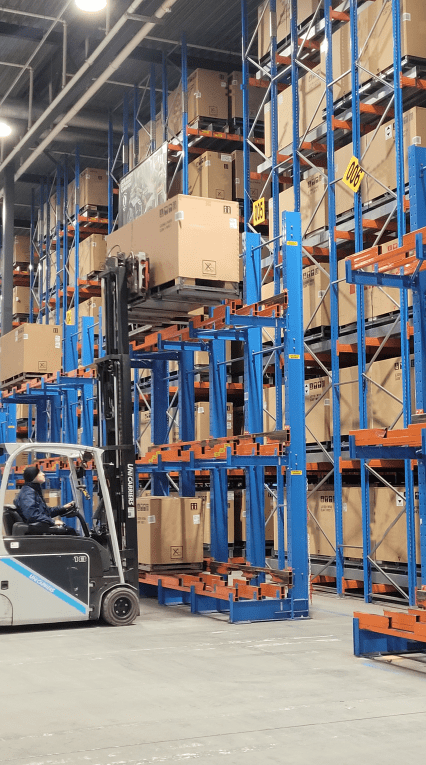 Packages in an ID Logistics warehouse. Employee in a forklift truck.