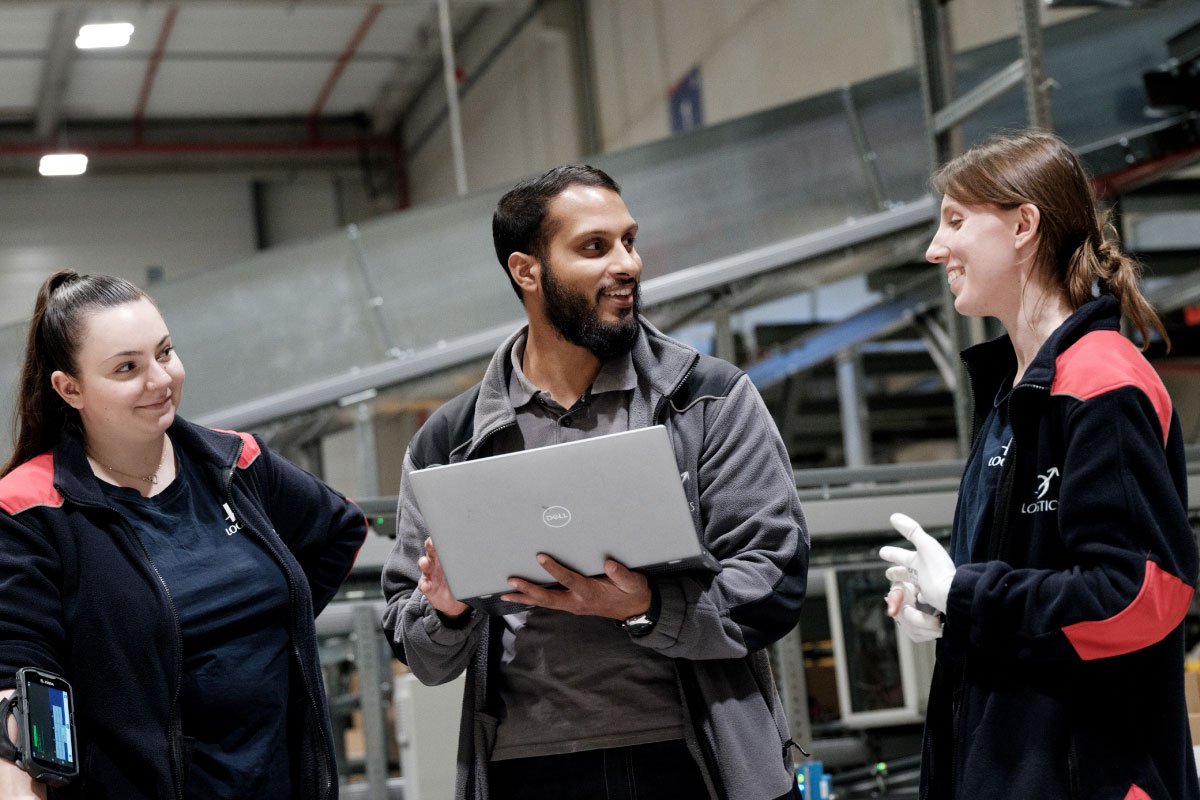 ID Logistics employees in a warehouse with a computer.