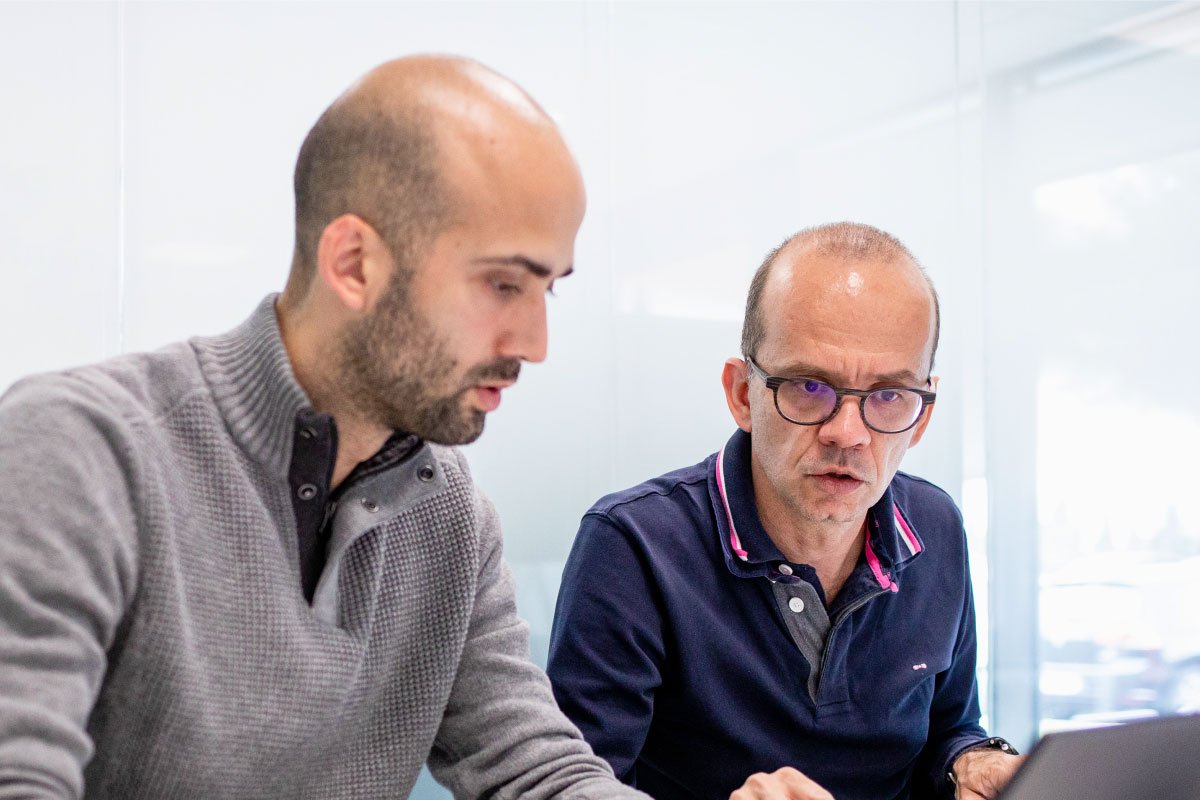 ID Logistics employees working on a computer.